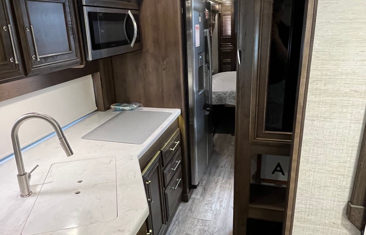 Hall space between refrigerator and bathroom with slides in.