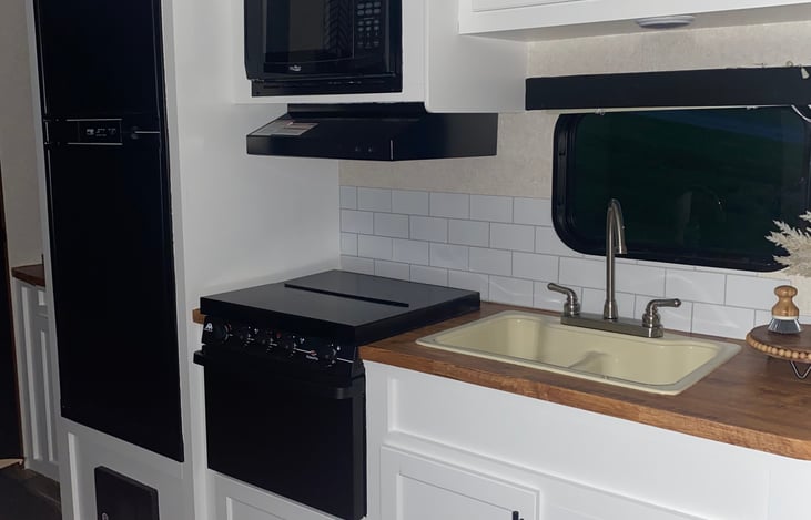 Kitchen.  toaster. coffee maker. pots. microwave. gas stove. fridge. freezer.