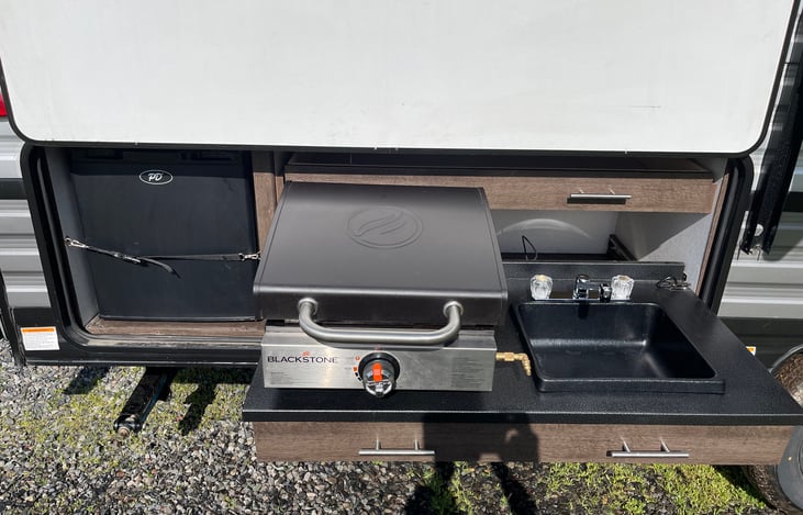 Super nice outdoor kitchen with sink, drink fridge, and blackstone griddle!