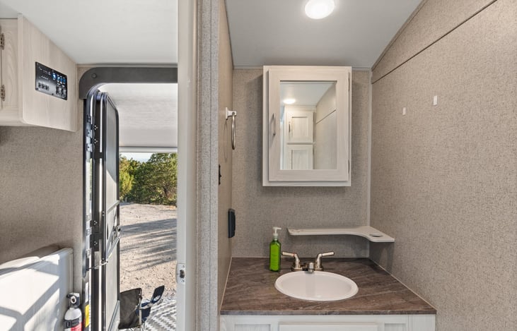 Bathroom sink with storage behind mirror.