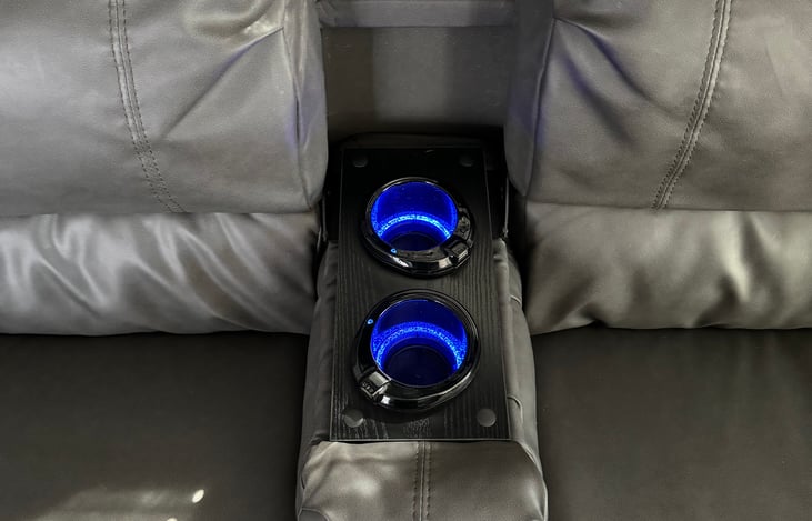 Arm rest for the couch pulls down creating a space to not only hold your drinks but charge your electrical devices. Each cupholder is equipped with a USB charging port and illuminates.