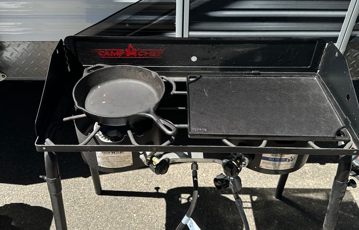 Outdoor camp grill with propane tank and cast iron griddle/pan
