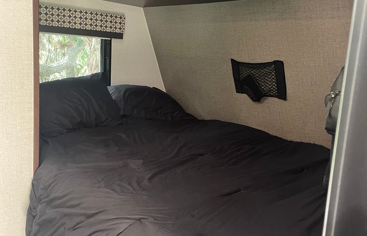 RV Queen bed with plenty of touch lighting, storage pockets and TV hanger if you want to watch TV in bed.