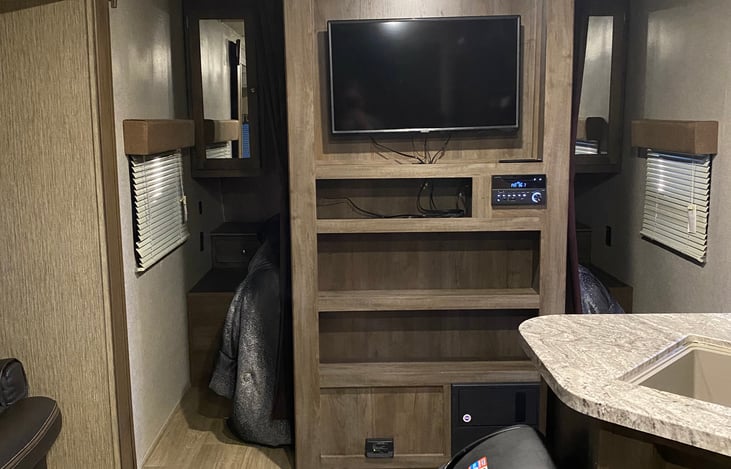 Master bedroom behind tv. has two night stands two windows and storage under bed and two closets to hang clothes. Queen size bed.