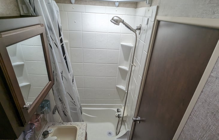 Bathroom includes an upgraded handheld shower head and an expandable shower curtain rod, which gives more elbow room for adults. There is even a bathtub for small kiddos!