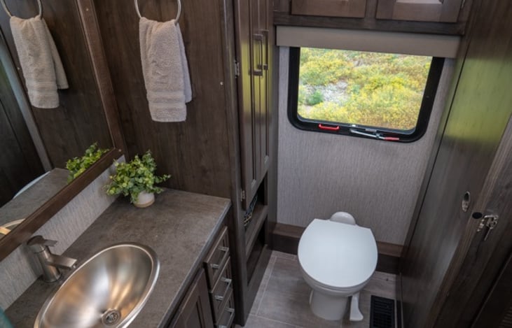 primary bathroom features ample storage, large shower, large vanity, and toilet.  Fully stocked with toilet paper, towels, and basic toiletries