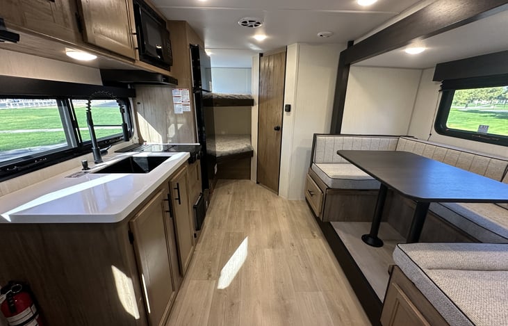 Interior walkway showing kitchen, dinette, bathroom access, and storage.