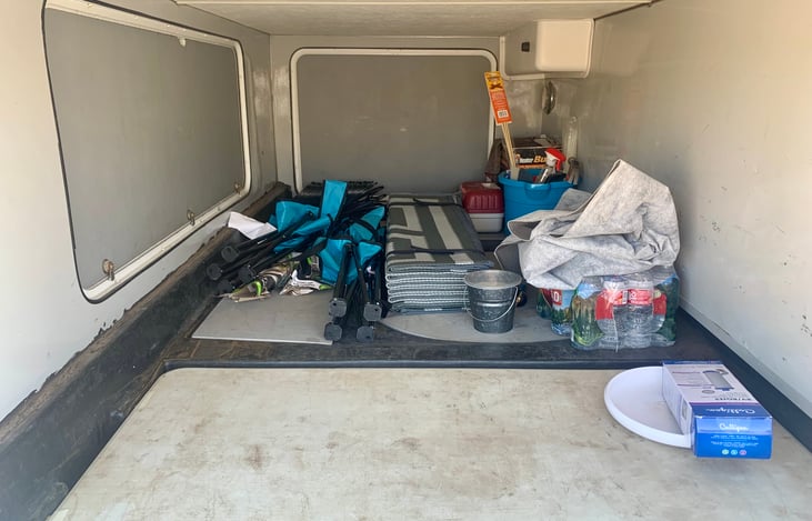 under cabin storage space. Two folding chairs, outdoor carpet. table