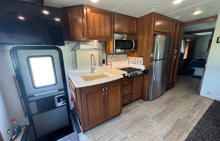 Full size fridge, microwave & 4 burner stovetop with cover for easy food prep.  Coffee Pot and Toaster included