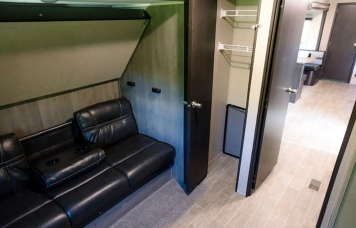 Bunk room with top bunk folded up and couch (also makes into bed) under it. Large closet for items.