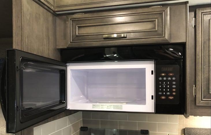 Large microwave above stove-top.