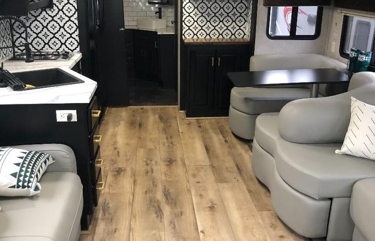 Living area, table, sink, gas stove.