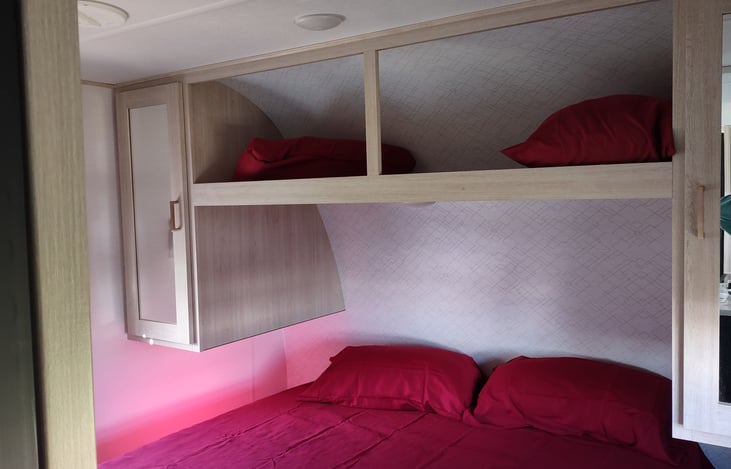 queen bdrm area with storage overhead and on each side of the bed