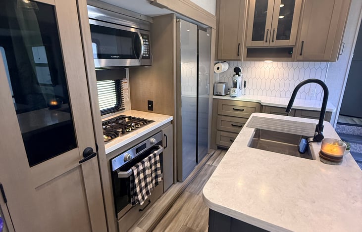 Main cabin kitchen view with pantry, stove, oven, microwave and a Furrion 16 cu ft fridge/freezer (electric/battery).