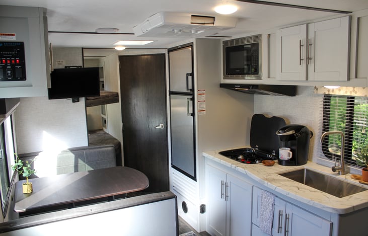 To the left- you will find our dinette which also doubles as another sleeper! A better view of our double bunks, freezer/ fridge & the bathroom straight a head!
