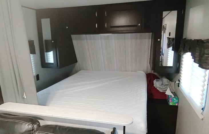 Queen-short mattress with storage over and on either side. 
Curtain closes for a bit of privacy.