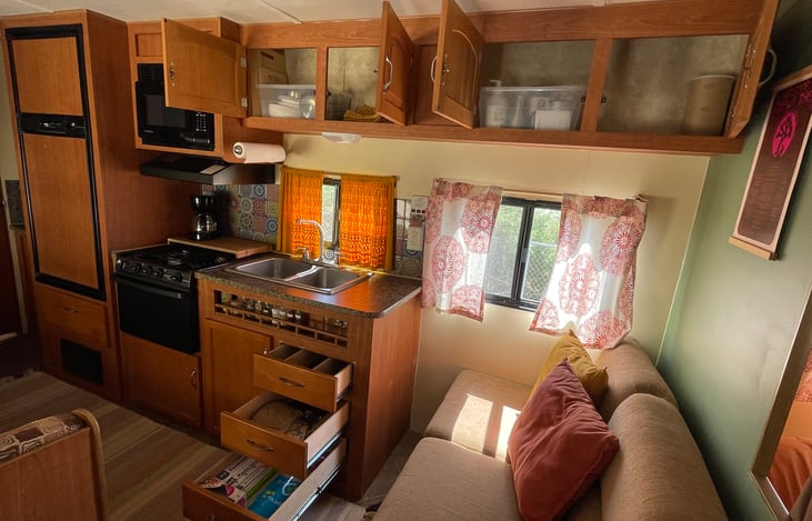 Kitchen with cupboards opened to show storage.