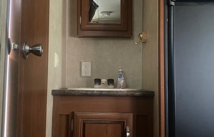 Bathroom sink with medicine cabinet above
