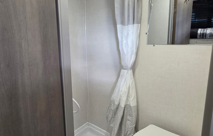 Bathroom with foot flush toliet and stand in shower