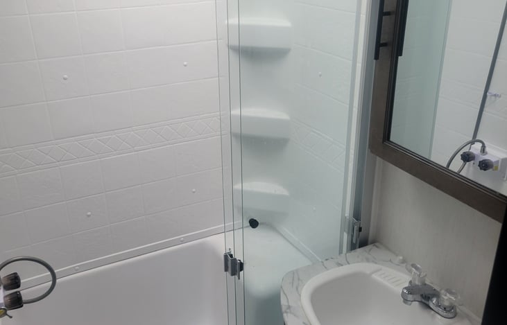good size shower with seat and porcelain toilet