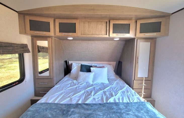 Queen bed with storage under the bed, 2 closets and overhead storage.