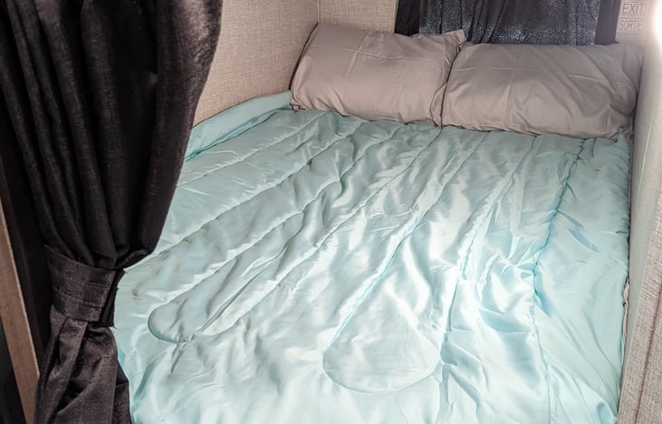 Double bed sized bunk beds each with their own privacy curtain, reading light, window, and power. (pictured with Extra linen package)