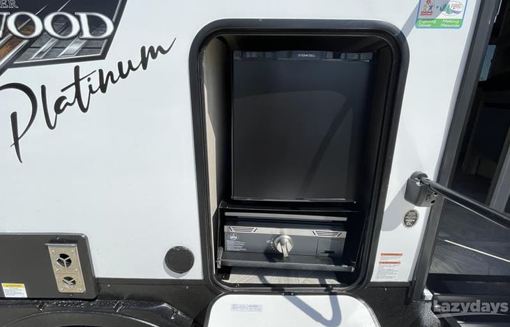 Exterior small fridge and flat top.