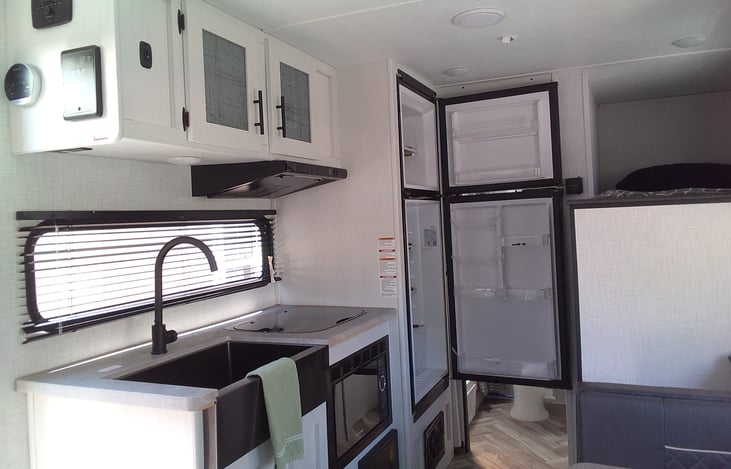 Extremely convenient kitchen with sink, countertop stove, microwave, and even an accommodating fridge 😋