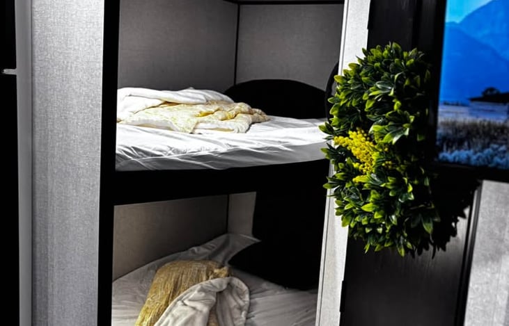 A bright and cozy double bunk area offering two comfortable beds, perfect for kids or extra guests on your trip. Fits two on each bunk.