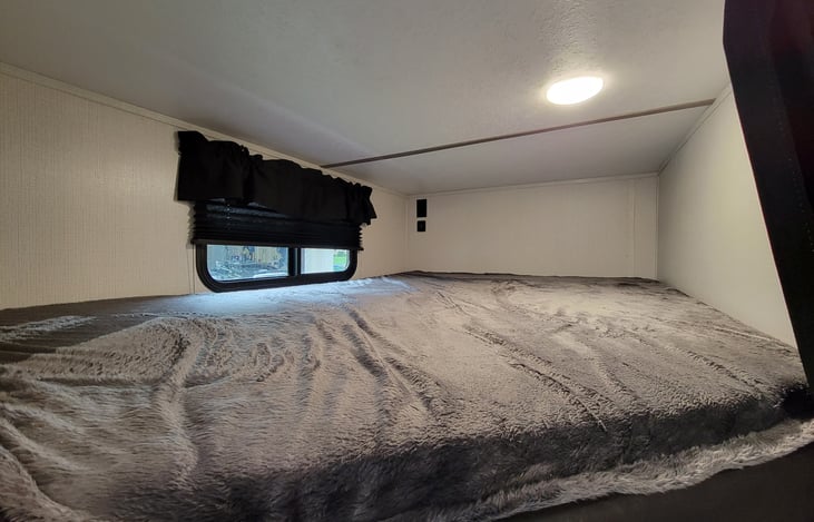 Top Bunk with room enough for an adult. Each bunk has a 110 AC outlet and 2 usb 12V plugs. Same size in lower bunk as well.