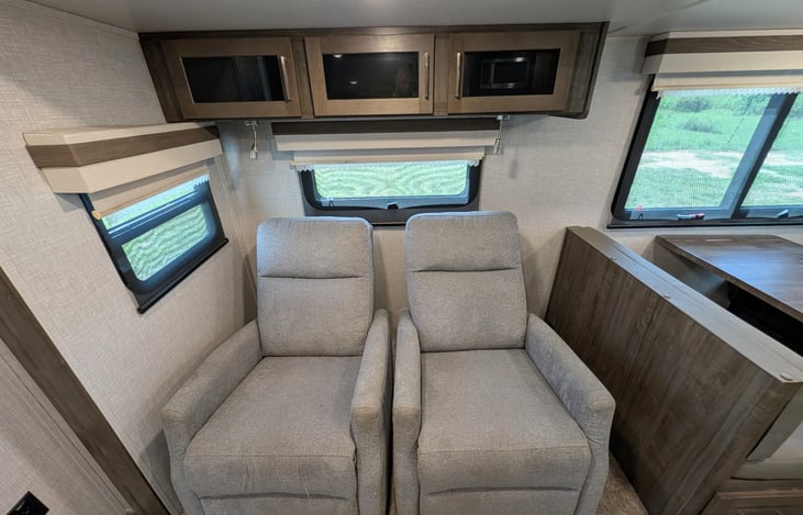 Spacious open-concept living area w/ dual recliners, TV & fireplace. Full kitchen features a residential fridge, 3-burner stove, oven, microwave, deep sink & booth dinette! Natural light throughout.