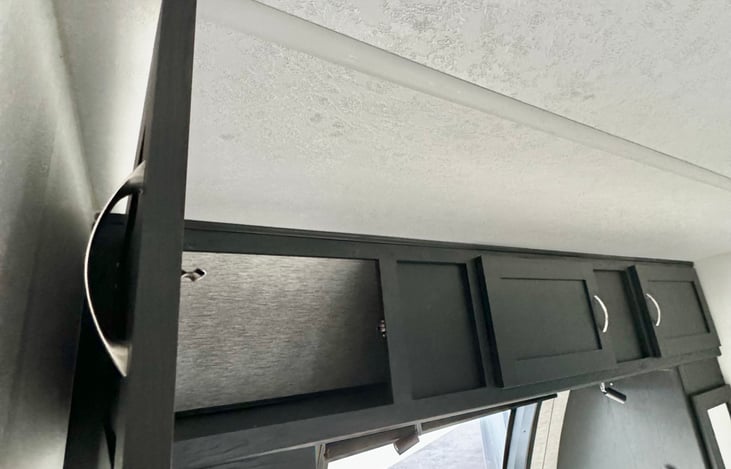 Over the bed storage has three doors that all connect to one storage compartment.