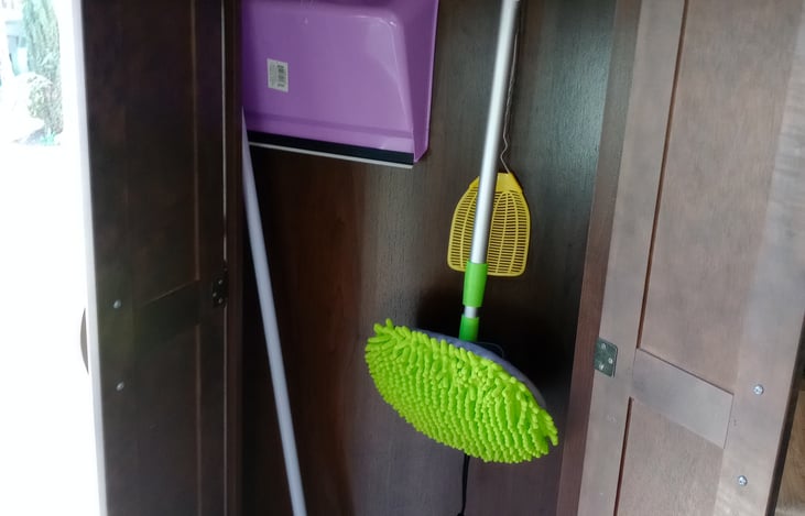 Broom closet for cleaning tools with handy dust-buster.