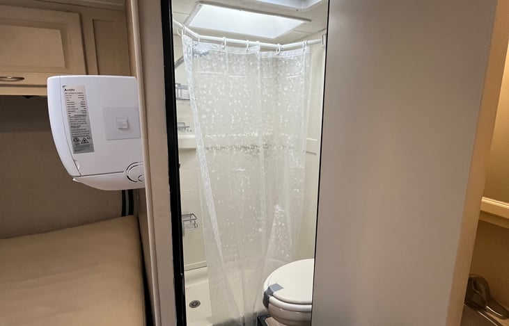Bathroom with shower and extend-a-shower curtain rod for a roomier shower experience. Shower also contains several shower caddies to hold all your shower necessities.