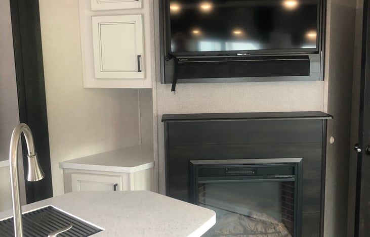 Living room offers electric fireplace and large TV with Roku.