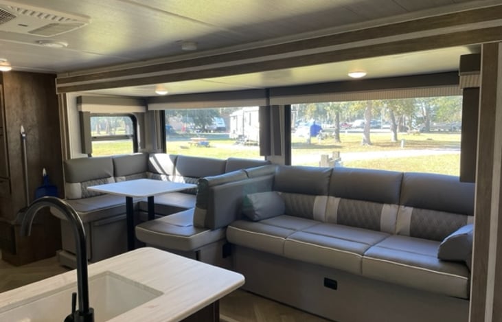 The table seating area and couch both convert to  queen beds