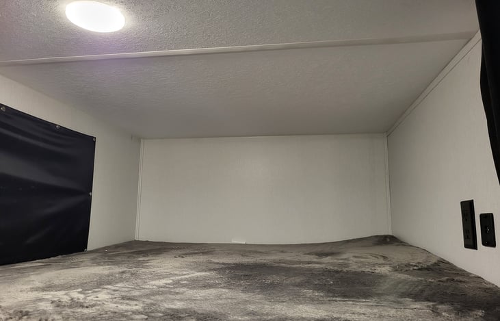 Top bunk with electric and usb receptacles with window and snap on blackout window coverings.