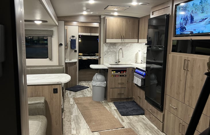 Front of RV has queen mattress (upgraded to a household queen mattress). Bathroom is between 2 sets of doors with a shower and sink.