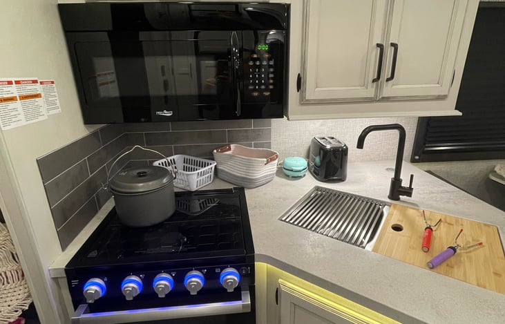 This is an electric microwave, a 3-burner gas stove and a gas oven.  Waffle maker, pots, marshmallow roasting stick skewer and toaster is included in price.