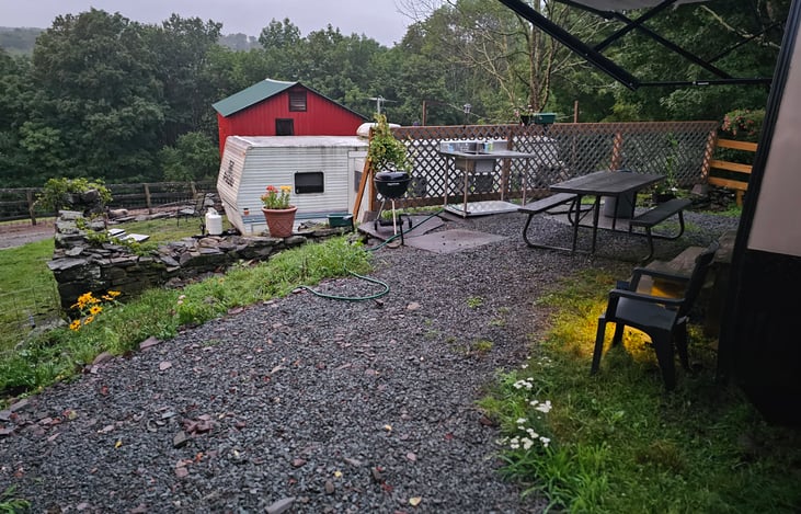 Outdoor sink, picnic table, umbrella, awning, enclosed area landscaped with flowers and trees, views of the mountains and our friendly flock of sheep!