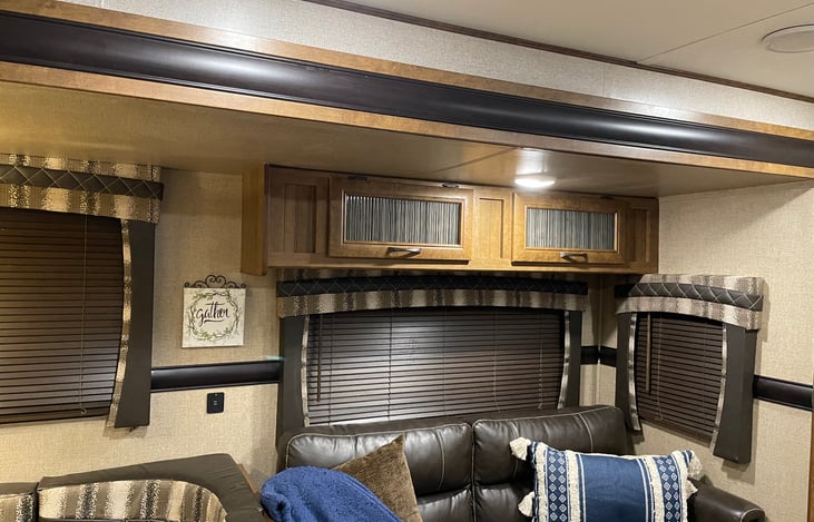 Lounge couch (converts to bed).    Above cabinets contains dinner dishes, salad plates, bowls (set of 8)  8 oz glasses, 4 oz. glasses (set of 8), 2 large serving bowls, extra coffee mugs