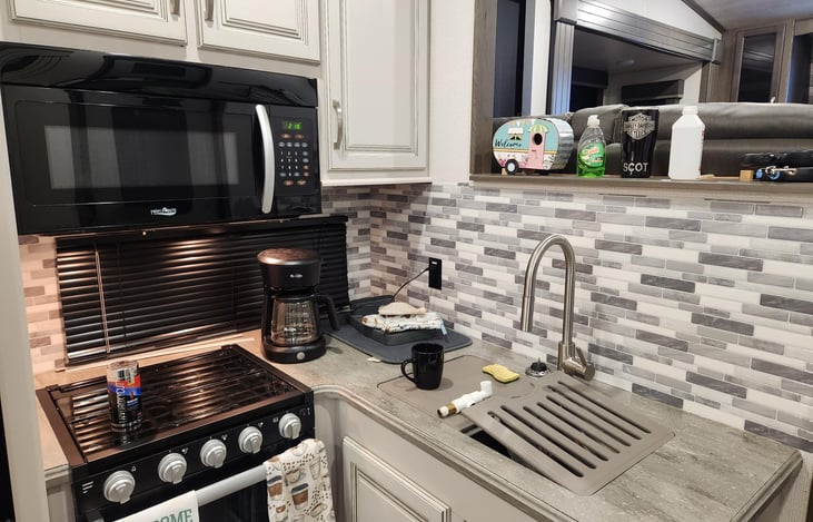 Kitchen sink, stove and microwave.