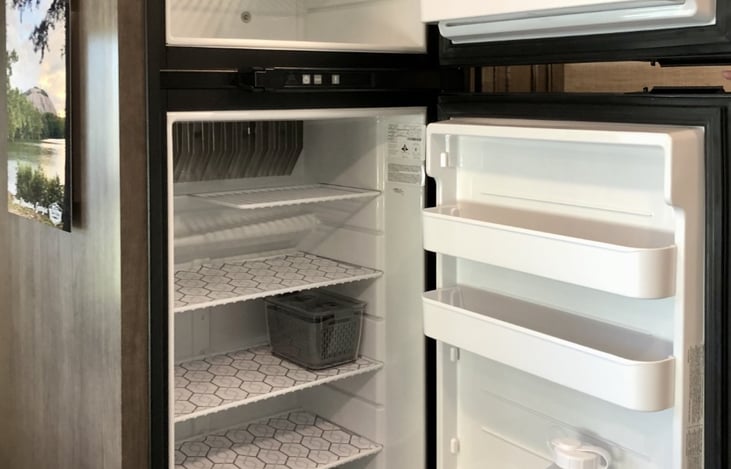 Refrigerator and freezer with temperature control. Powered by either electricity while plugged in at camp, or by propane if you are boon-docking.