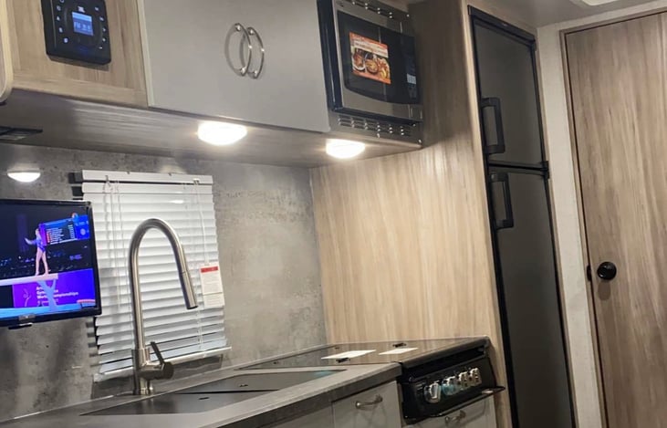 Kitchen with gas stove and convection microwave and large sink.