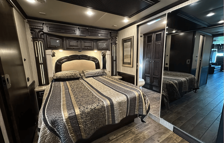queen size bed with mirrored doors to bath