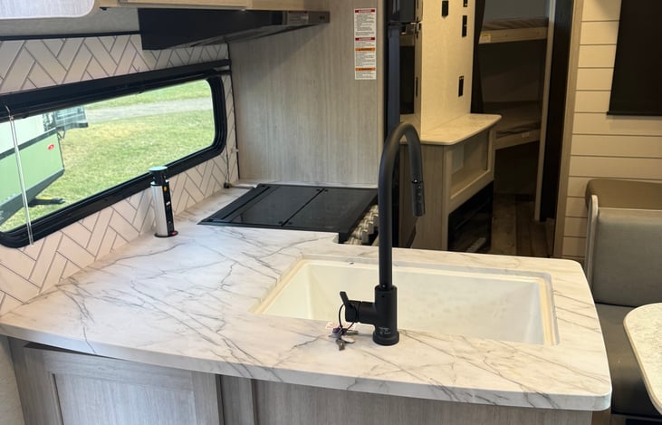 Farmhouse style sink with plenty of counter space for those nice camping breakfasts! With detachable sprayer sink head making for easy cleaning of those dirty dishes!