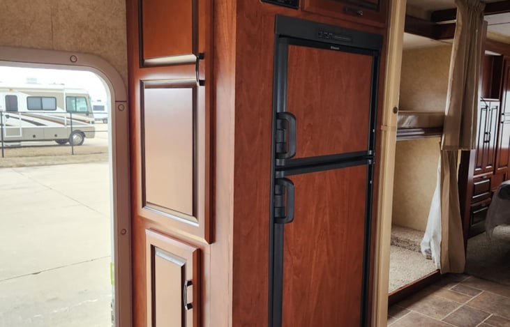 Fridge and Freezer on top. Lots of room in both, side cupboard we usually place canned goods in the top cupboard, it is hard to open so that nothing falls out.