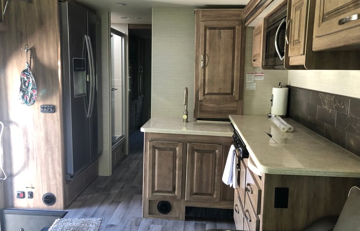 Galley with residential refrigerator with icemaker.