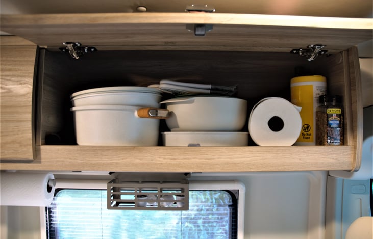 Cooking pots, pans, spices, olive oil, and cleaning wipes.