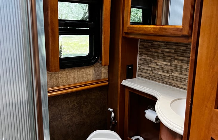 The 36GH Tiffin features a spacious bathroom with modern amenities for comfort and convenience during travels.